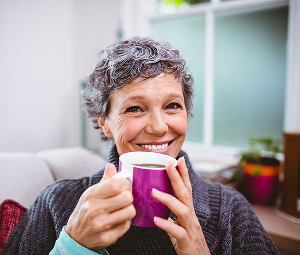elderly woman drinking a cup of coffee