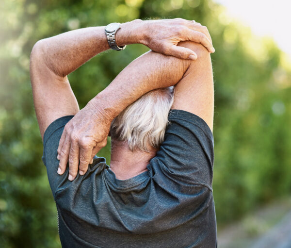 Rear view shot of a senior man warming up before a run outside